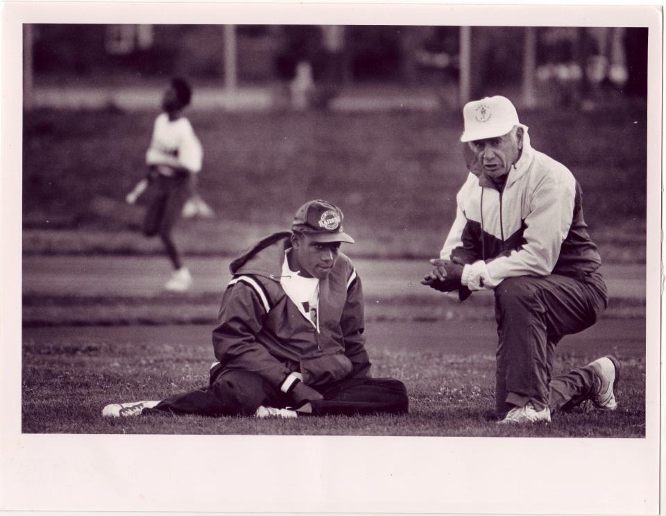 Sexton coach Paul Pozega talks to senior athlete Howard Triplett during a meet in 1991. Pozega died Feb. 2 at the age of 93.