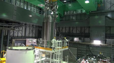 The cask with 22 fuel rods is lifted and moved by workers during operations to move the cask from the reactor building to another building, where a common fuel pool is located, at Tokyo Electric Power Co's (TEPCO) Fukushima Daiichi nuclear power plant in Fukushima prefecture, November 21, 2013, in this handout video grab image taken and released by TEPCO. REUTERS/Tokyo Electric Power Co/Handout via Reuters