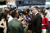 Mario Cristobal, right, is interviewed by the news media after being introduced as Miami's football coach during a news conference Tuesday, Dec. 7, 2021, in Coral Gables, Fla. Cristobal is returning to his alma mater, where he won two championships as a player. (AP Photo/Lynne Sladky)