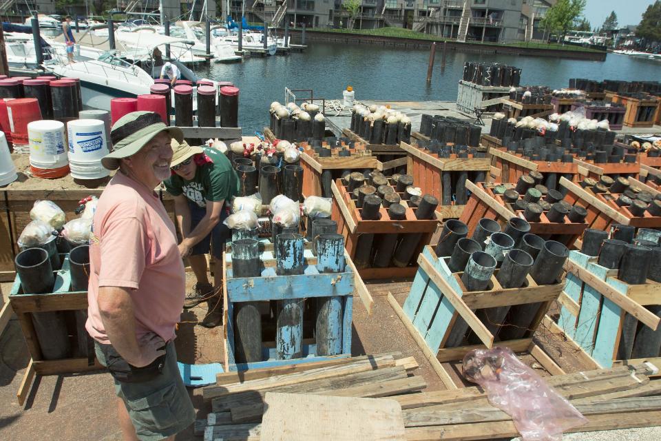 In a on July 2, 2013 photo, Chuck Amalong, left, and Brent Mattix help prepare Lake Tahoe’s Fourth of July fireworks display at Tahoe Keys Marina in Lake Tahoe, Calif. A federal lawsuit accusing the Lake Tahoe Visitors Authority of polluting the alpine lake with debris from Fourth of July and Labor Day fireworks says the authority and its contractor should be subject to up to $75 million in fines for thousands of violations of the Clean Water Act over the past five years. (AP Photo/The Tahoe Daily Tribune, Dylan Silver)