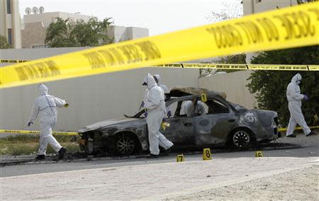 Forensic experts investigate at the scene of a car explosion in the village of al-Maqshaa, west of Manama April 19, 2014. REUTERS/Hamad I Mohammed