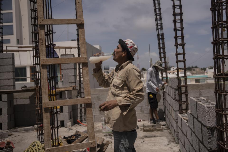 Jorge Moreno, a worker, drinks flavored water to cope with the heat wave during his workday at a construction site in Veracruz, Mexico, on June 17, 2024. Human-caused climate change intensified and made far more likely this month's killer heat with triple digit temperatures, a new flash study found Thursday, June 20. (AP Photo/Felix Marquez)