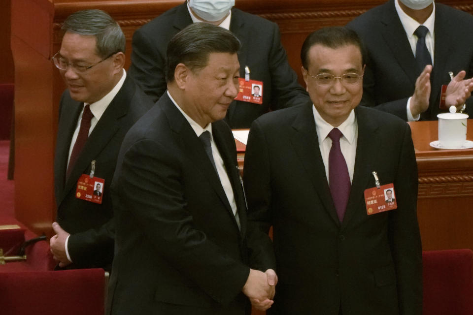 FILE - Newly elected Chinese Premier Li Qiang, at left, walks past as Chinese President Xi Jinping, center, shakes hands with former Premier Li Keqiang, at left during a session of China's National People's Congress (NPC) at the Great Hall of the People in Beijing, Saturday, March 11, 2023. Former Premier Li Keqiang, China’s top economic official for a decade, died Friday, Oct. 27, 2023 of a heart attack in Shanghai, state media CCTV reported. He was 68. (AP Photo/Mark Schiefelbein, File)