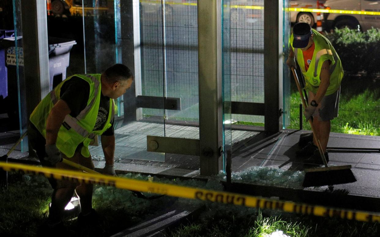 Workers clean up broken glass after the Holocaust Memorial was vandalised in Boston - REUTERS