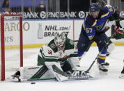 Minnesota Wild goaltender Cam Talbot (33) makes a stick save as St. Louis Blues' David Perron (57) looks for the loose puck in the second period of an NHL hockey game, Wednesday, May 12, 2021 in St. Louis. (AP Photo/Tom Gannam)