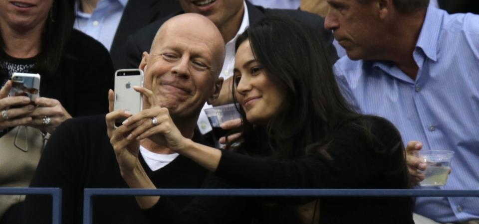 Bruce Willis, left, and wife Emma Heming take a selfie as Marin Cilic, of Croatia, faces Kei Nishikori, of Japan, during the championship match of the 2014 U.S. Open tennis tournament, Monday, Sept. 8, 2014, in New York. (AP Photo/Charles Krupa)