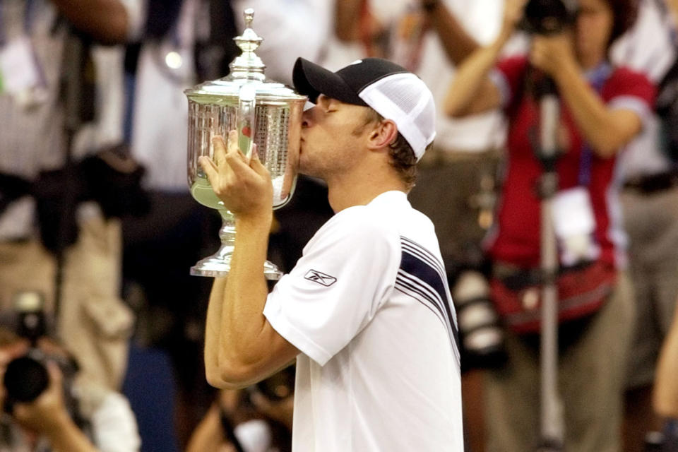 FILE - Andy Roddick, of the United States, kisses the men's singles championship trophy after defeating Juan Carlos Ferrero, of Spain, at the U.S. Open tennis tournament in New York, Sept. 7, 2003. Roddick was the last American man to win a Grand Slam singles title, and that drought will be a topic of conversation during this year's U.S. Open, which starts Monday, Aug. 28, 2023. (AP Photo/Kathy Willens, File)