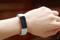 <p>Slightly off angle view of the Fitbit Luxe with a light pink silicone band on a wrist against a dark brown background. The screen shows a calendar notification for an event from 5:30pm to 7pm.</p> 