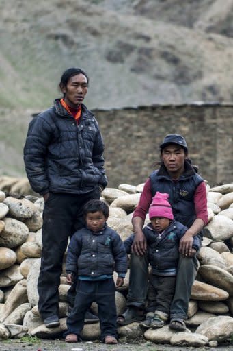 This handout photo, released by www.thegreathimalayatrail.org on September 18, shows brothers Pasang (L) and Mingmar Lama, who share a wife in a polyandrous marriage, posing with their children Kanjuk and Jigme outside Mingmar's trading post in the remote Himalayan region of Upper Dolpa, some 500 km from the Nepalese capital Kathmandu