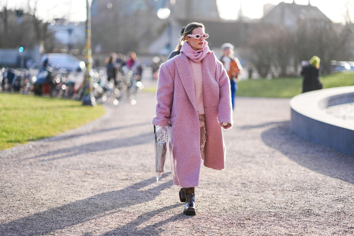 COPENHAGEN, DENMARK - FEBRUARY 01: A guest wears a pink full outfit, sunglasses, a fluffy long oversized blazer jacket , a pullover leather boots , outside Marimekko, during the Copenhagen Fashion Week AW24 on February 01, 2024 in Copenhagen, Denmark. (Photo by Edward Berthelot/Getty Images)