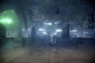 A firefighter disinfects the shrine of Saint Saleh to help prevent the spread of the new coronavirus in northern Tehran, Iran, Friday, March, 6, 2020. A Health Ministry spokesman warned authorities could use unspecified "force" to halt travel between major cities. (AP Photo/Ebrahim Noroozi)