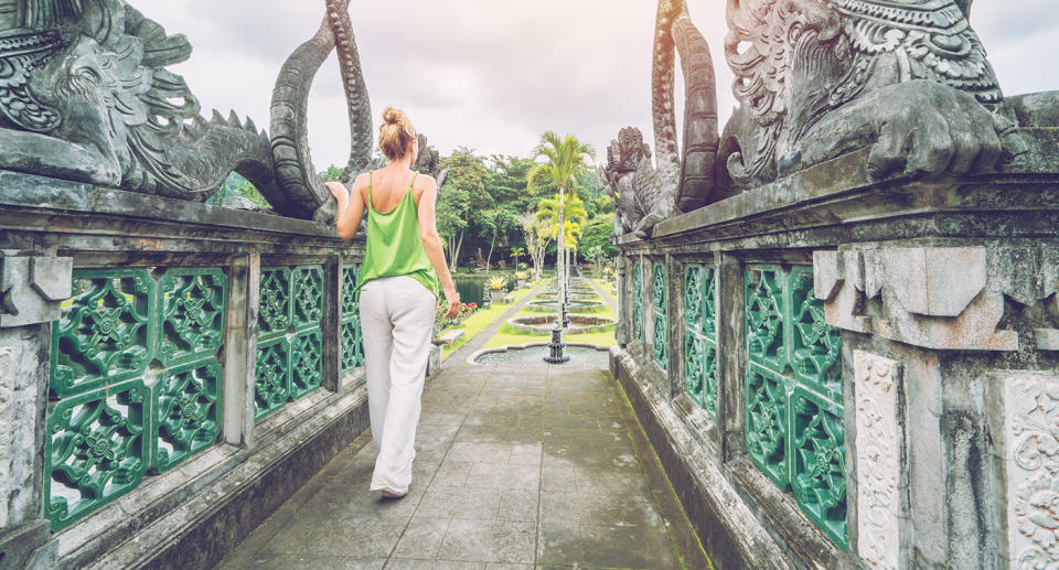 A young woman visits Bali's Tirta Gangga temple. Indonesian Authorities could soon ban tourists from visiting temples unaccompanied.