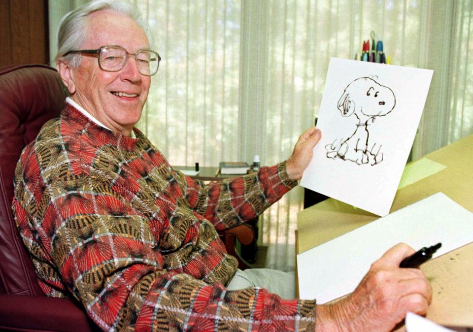 FILE--Cartoonist Charles Schulz displays a sketch of his beloved character "Snoopy" in his office in Santa Rosa, Calif., in this 1997 file photo. (AP Photo/Ben Margot, File)