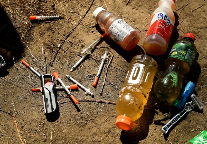 LOS ANGELES CALIFORNIA MARCH 26, 2021-Syringes left behind from a homeless pereson are gatered during clean-up in Echo Park Friday. (Wally Skalij/Los Angeles Times)