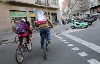 A father carries the backpack of his daughter as they ride their bicycle home after Catalonia announced to close schools, kindergartens, institutes and universities from tomorrow as a precaution against coronavirus in Barcelona