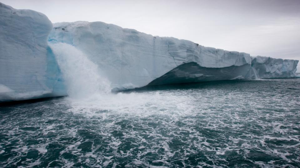 A photo of water pouring from a melting Arctic glacier