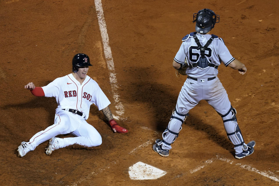 Boston Red Sox's Jarren Duran slides into home plate to score on a double by Enrique Hernandez as New York Yankees catcher Rob Brantly waits for the throw during the ninth inning of a baseball game at Fenway Park, Thursday, July 22, 2021, in Boston. (AP Photo/Elise Amendola)