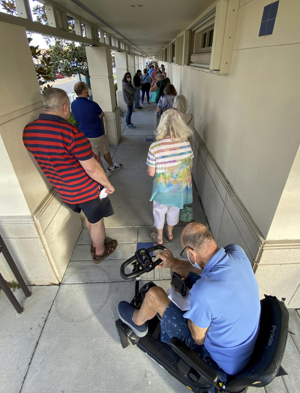 People wait in a line in Sarasota, Fla., Thursday morning, Dec. 31, 2020, as COVID-19 vaccinations were made available to those over 65 and high-risk frontline health care workers. (Tom Stathis via AP)