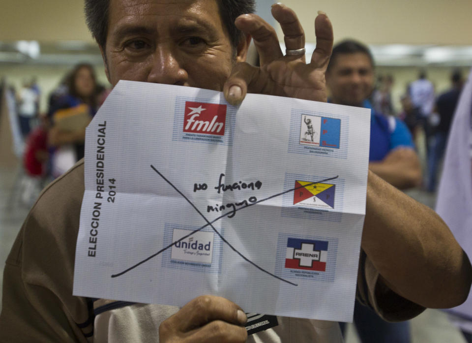 ADDS TRANSLATION OF INVALIDATED BALLOT - An election officer shows an invalidated ballot with handwriting that says in Spanish "None of them work", while counting votes at a polling station in San Salvador, El Salvador, Sunday, Feb. 2, 2014. Presidential elections in two Central American countries are both referendums on political stagnation, with voters in Costa Rica deciding whether to oust the long-ruling party, and voters in El Salvador deciding whether to bring it back to power. (AP Photo/Esteban Felix)