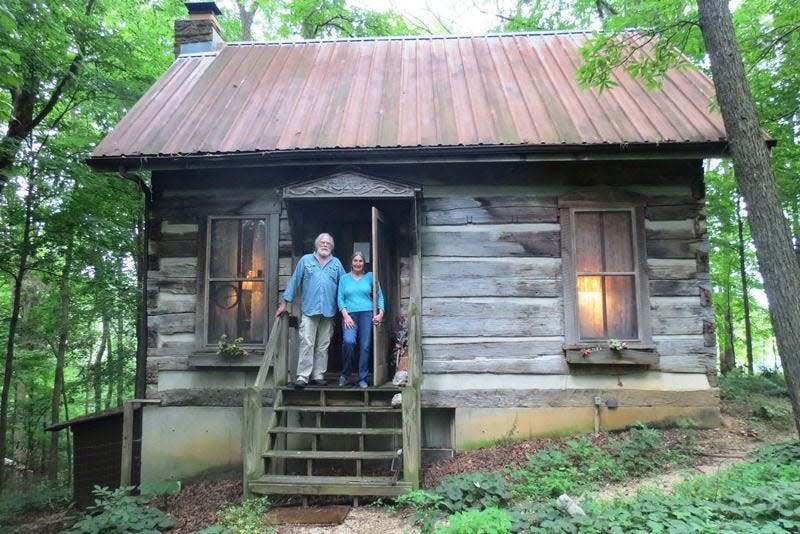 James Alexander and Dark Rain Thom stand on the porch of their pre-Civil War log cabin off of Stogsdill Road.