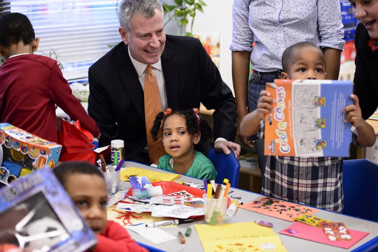 New York City Mayor Bill de Blasio distributes toys to children at the Women in Need (WIN) shelter in the East New York section of Brooklyn on December 23, 2015.