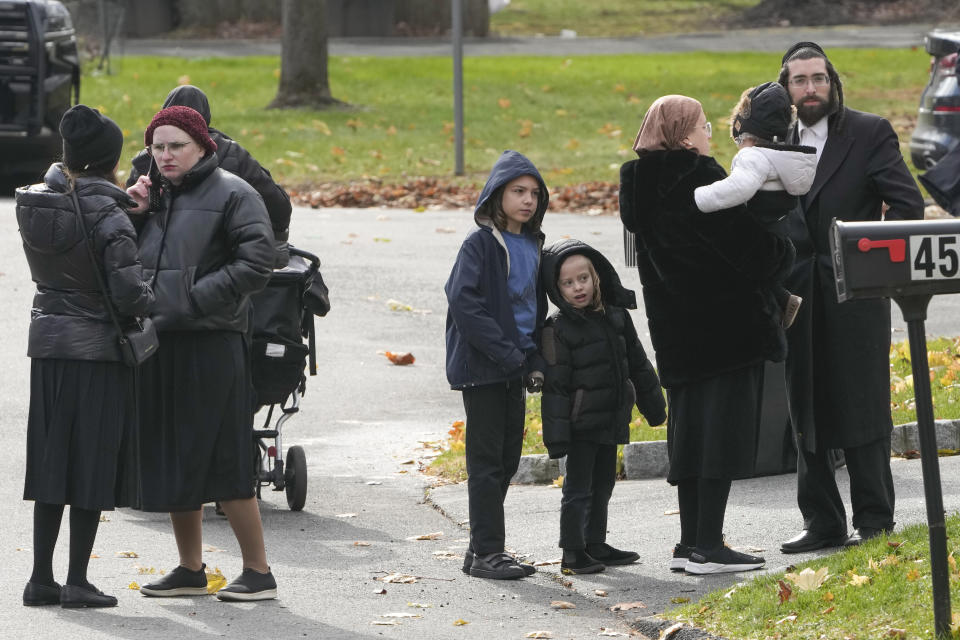 Orthodox Jewish families, some of whose children were on the bus, look at the site of a school bus accident in the village of New Hempstead in Rockland County, N.Y., Thursday, Dec. 1, 2022. (AP Photo/Seth Wenig)