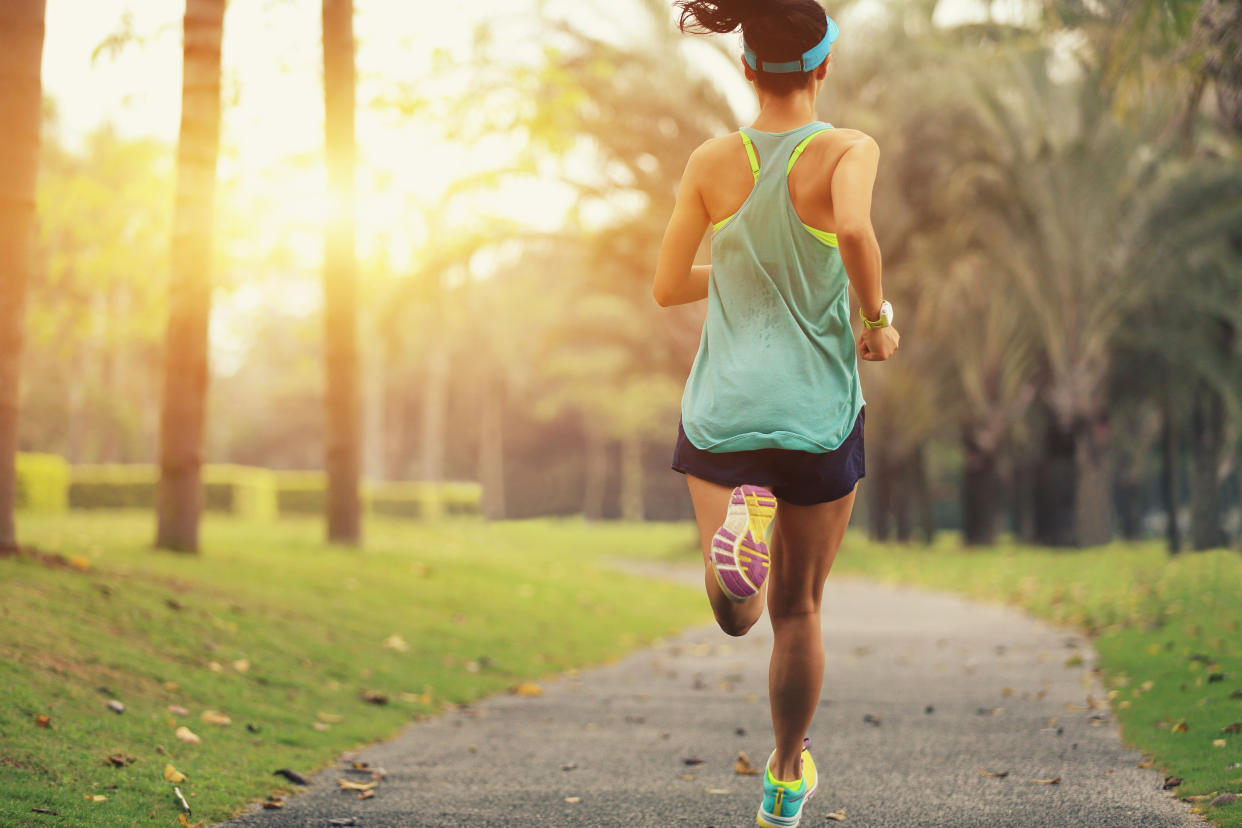 healthy lifestyle young sporty asian woman running at tropical park