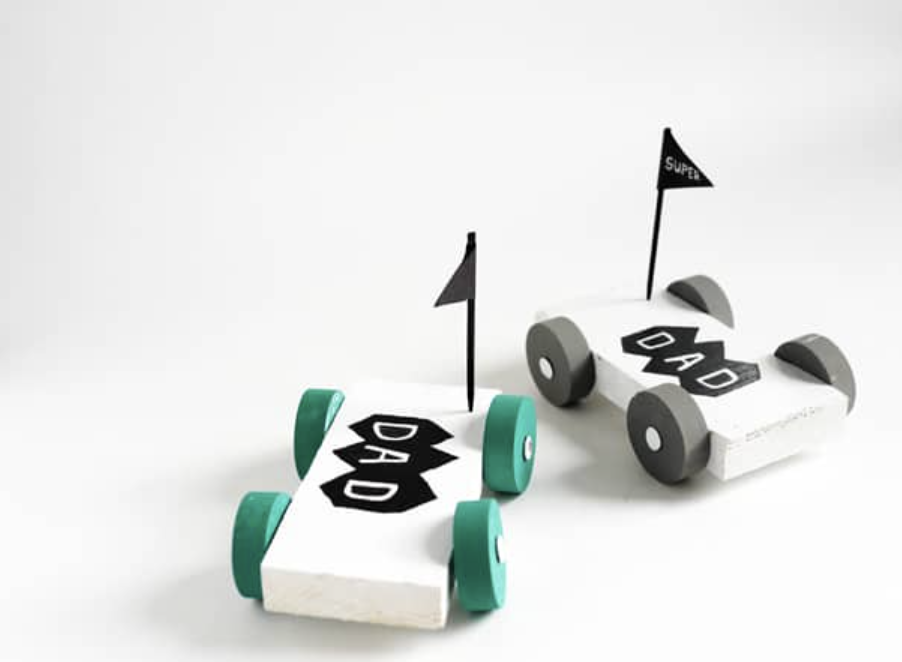 father's day crafts, two small white wooden toy cars with black flags