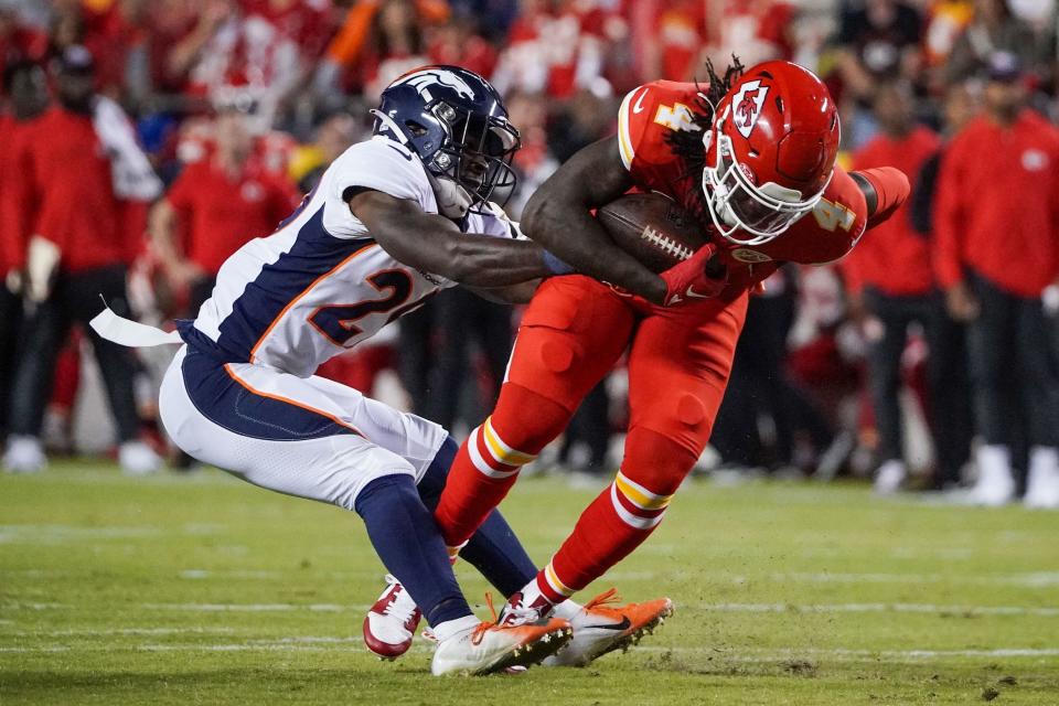 Kansas City Chiefs wide receiver Rashee Rice runs the ball as Denver Broncos cornerback Ja'Quan McMillian makes the tackle during the game at GEHA Field at Arrowhead Stadium.