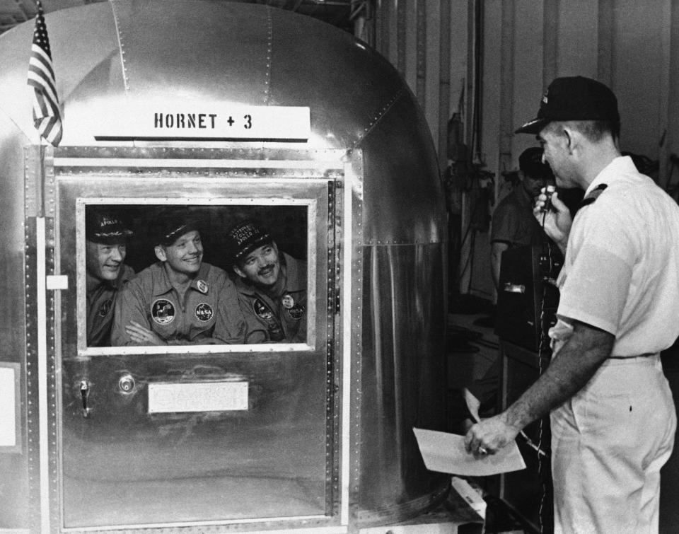 FILE - In this July 25, 1969, file photo, Capt. Carl Seiberlich, commander of the carrier Hornet, right, says goodbye to Apollo 11 astronauts Edwin Aldrin Jr., from left, Neil Armstrong and Michael Collins in Honolulu, Hawaii, before they were taken in their quarantine van to a waiting cargo plane to be flown to Houston, Texas. This week marked the 50th anniversary of the moon landing, but after those historic first steps NASA still had to get the three astronauts safely back to Earth, and the waters off Hawaii are where the cone-shaped spacecraft splashed down. (AP Photo, File)