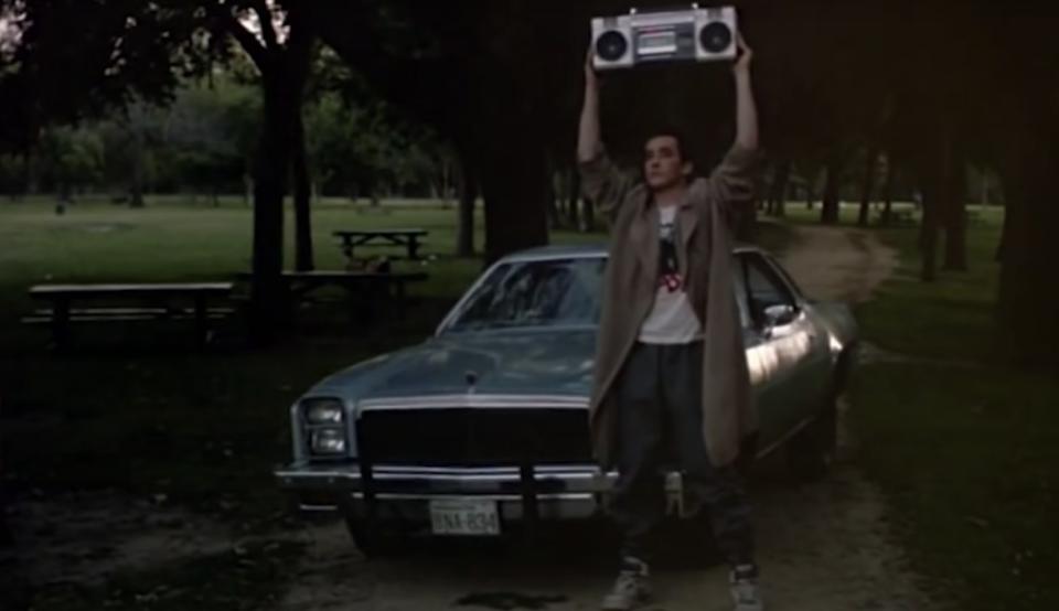 John Cusack holding a boom box above his head in a scene from "Say Anything"