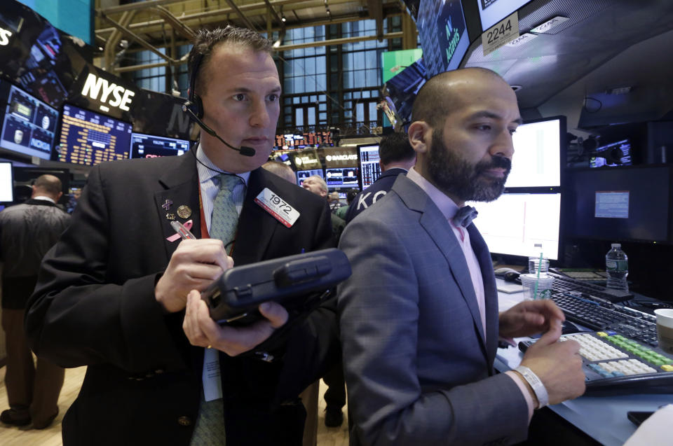 Trader Jonathan Corpina, left, and specialist Fabian Caceres work on the floor of the New York Stock Exchange, Friday, Feb. 21, 2014. U.S. stocks are inching higher in early trading, putting the Standard & Poor's 500 index on track for its third straight week of gains. (AP Photo/Richard Drew)