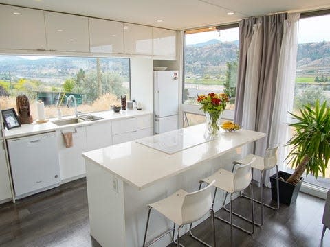 The all white kitchen with windows inside Cathi's shipping container house