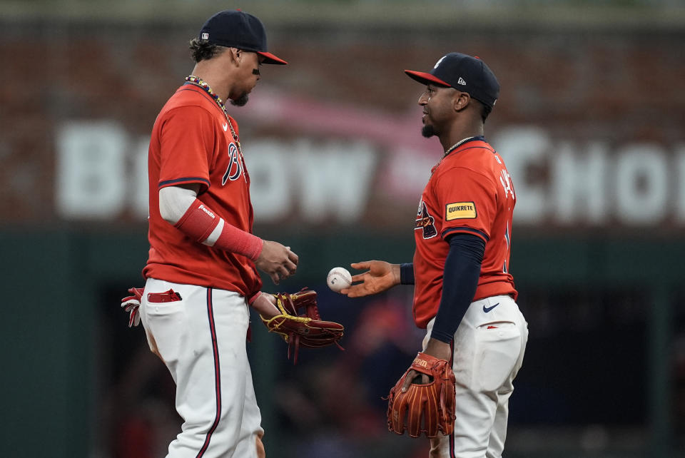 Atlanta Braves' Orlando Arcia (11) and Ozzie Albies celebrate a 6-2 win over the Cleveland Guardians after a baseball game, Friday, April 26, 2024, in Atlanta. (AP Photo/Mike Stewart)