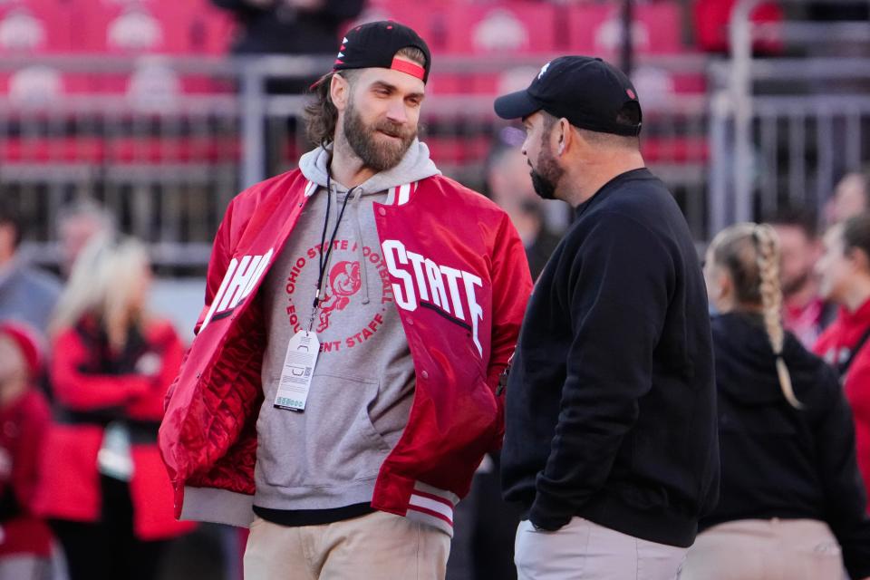 Philadelphia Phillies first baseman Bryce Harper talks to Ohio State coach Ryan Day prior to the Buckeyes' 37-3 win over Minnesota.