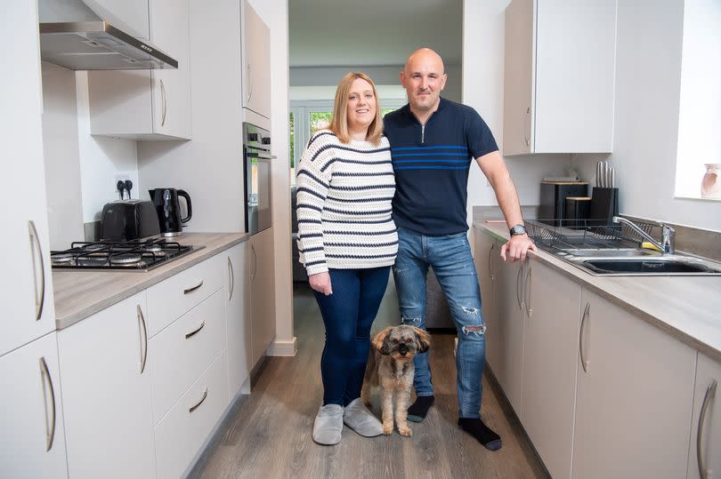 Sarah, Paul, and their dog Toby pictured in the kitchen