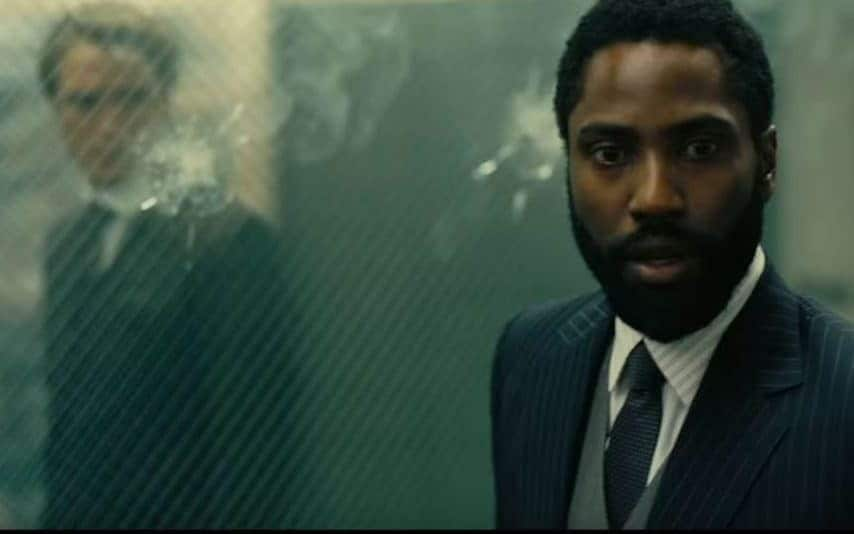 Robert Pattinson and John David Washington analyse a bullet-hole from the future - Warner Bros