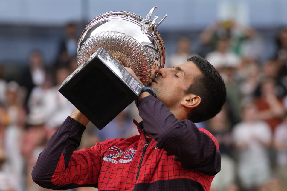 Novak Djokovic besa el trofeo de campeón tras derrotar a Casper Ruud en la final del Abierto de Francia, el domingo 11 de junio de 2023, en París. (AP Foto/Christophe Ena)