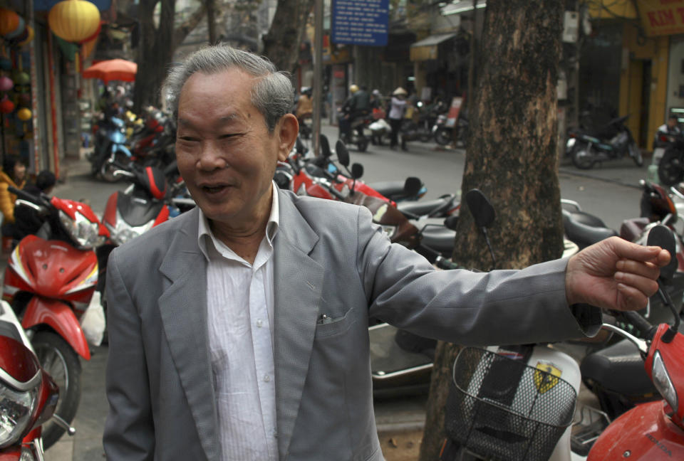 In this Jan. 27, 2014 photo, Pham Dinh Tranh, a retired jeweler, stands on Silver Street in the Old Quarter of Hanoi, Vietnam. The 82-year-old wouldn’t mind a change of scene: His home he shares with his extended family is cramped and the roof leaks. But he said Hanoi officials will need to make a convincing case for why he should leave. (AP Photo/Mike Ives)