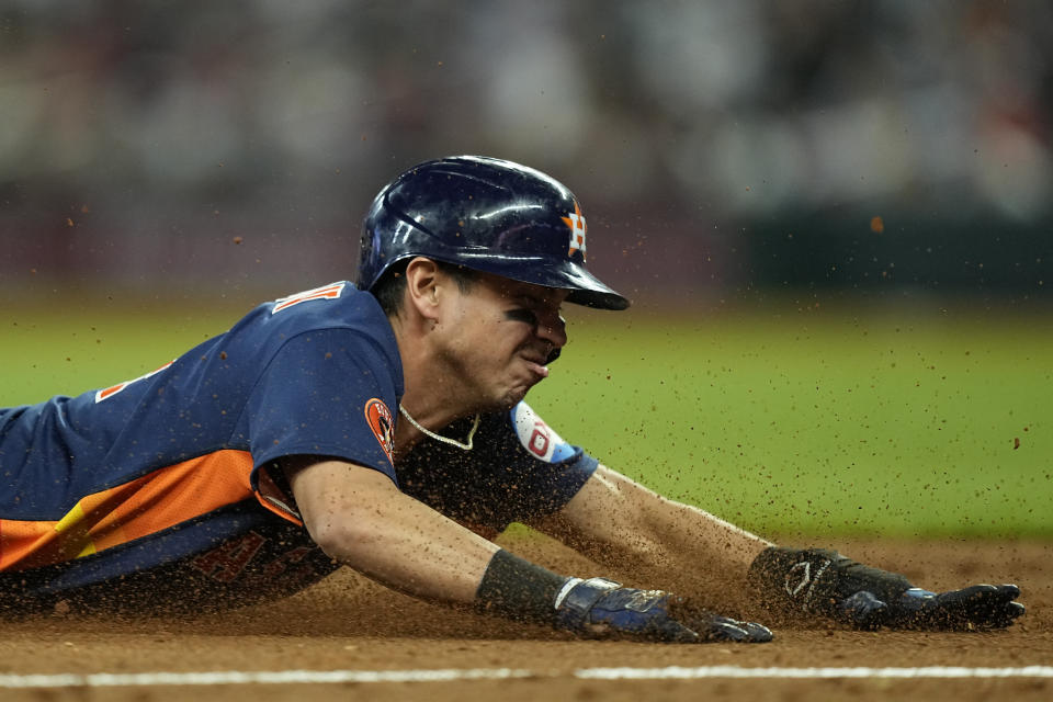 Houston Astros' Mauricio Dubon (14) safely slides into third base in the ninth inning of a baseball game against the Atlanta Braves, Saturday, April 22, 2023, in Atlanta. (AP Photo/Brynn Anderson)