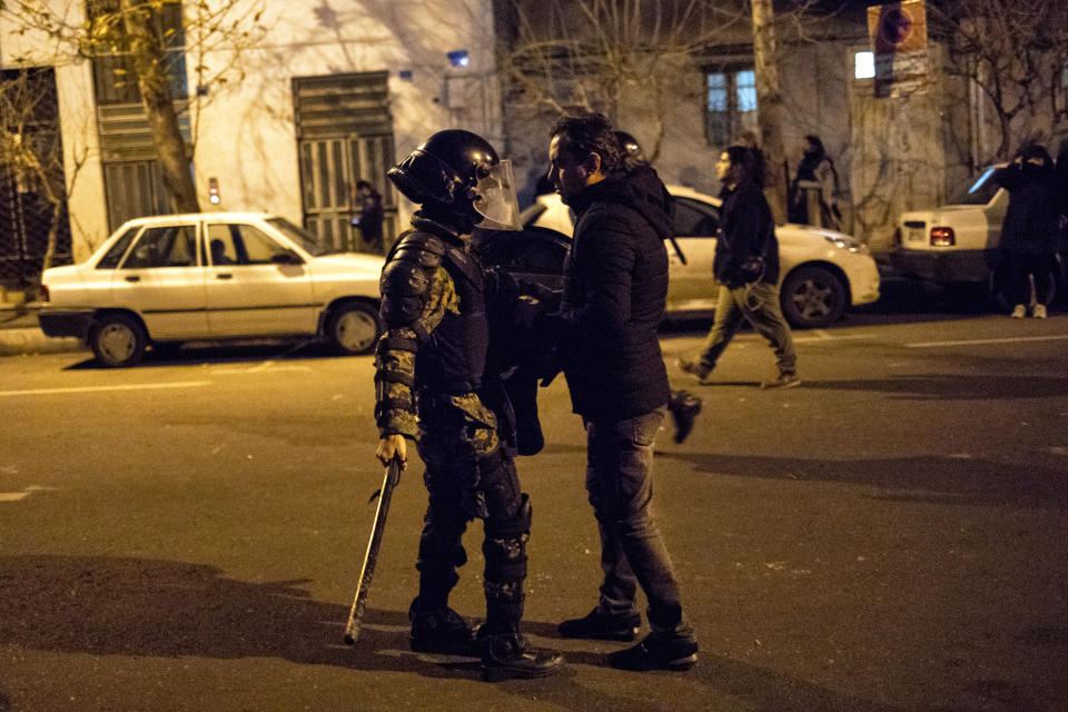 In this photograph taken Saturday, Jan. 11, 2020, a protester confronts an Iranian police officer while demonstrators gather in front of Amir Kabir University in Tehran, Iran, to remember victims of a Ukrainian airplane shot down by an Iranian missile. On Monday, Jan. 13, 2020, online videos purported to show that Iranian security forces fired both live ammunition and tear gas to disperse demonstrators protesting against the Islamic Republic's initial denial that it shot down a Ukrainian jetliner. (AP Photo)