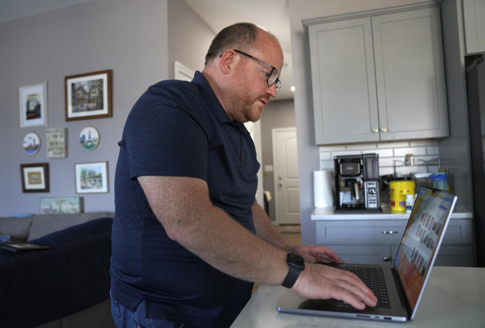 Former Jehovah's Witnesses elder and father of a sexual abuse victim, Martin Haugh, looks through old photos at his home in York Haven, Pa., on Wednesday, April 12, 2023. Haugh and his family left the faith in 2016, and in 2019 he testified in front of a Pennsylvania grand jury about the structure of the denomination and how it handles cases of child abuse. (AP Photo/Jessie Wardarski)