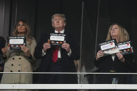 Former President Donald Trump and his wife Melania participate in the "stand up for cancer" campaign during the fifth inning in Game 4 of baseball's World Series between the Houston Astros and the Atlanta Braves Saturday, Oct. 30, 2021, in Atlanta. (AP Photo/David J. Phillip)