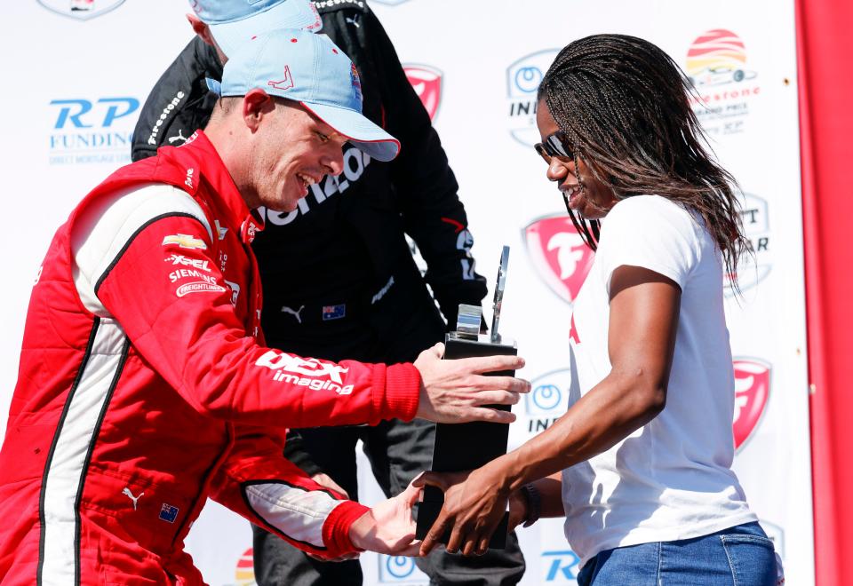 Feb 27, 2022; St. Petersburg, Florida, USA; Team Penske driver Scott McLaughlin (left) of New Zealand takes the champions trophy from US Olympic Gold Medalist Erin Jackson (right) after winning the IndyCar Firestone Grand Prix of St. Petersburg at Streets of St. Petersburg. Mandatory Credit: Reinhold Matay-USA TODAY Sports