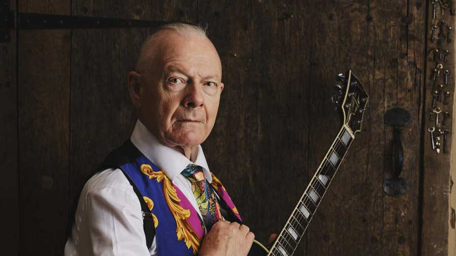  Robert Fripp holding a guitar. 