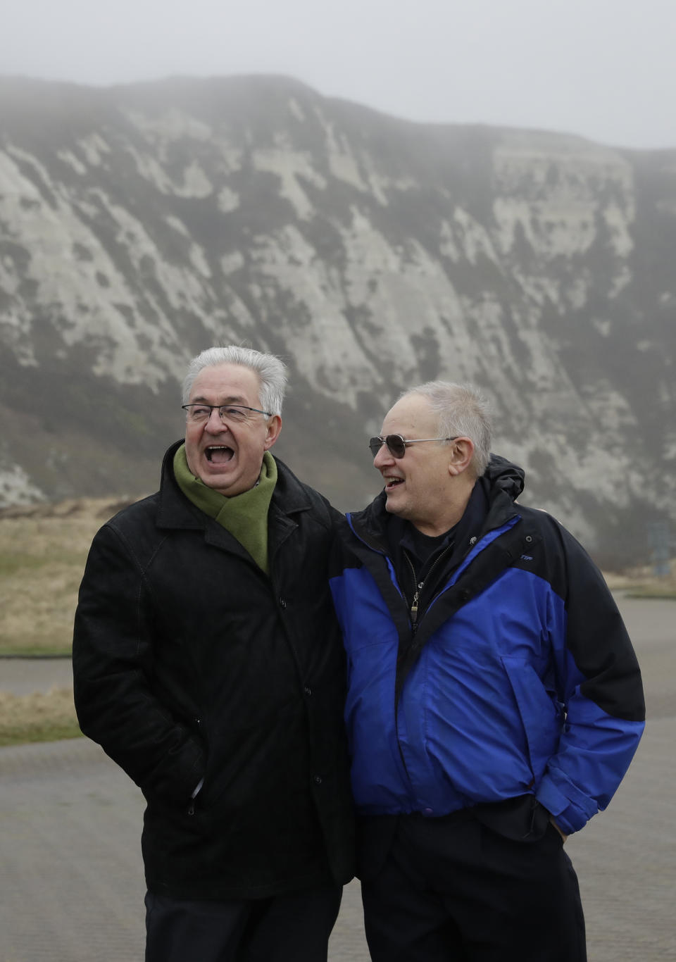 Former British Channel Tunnel worker Graham Fagg, right, and Former French Channel Tunnel worker Philippe Cozette pose for photographs together at Samphire Hoe, a site made from the disposal of the Channel Tunnel chalk marl spoil at the base of Shakespeare Cliff near Dover, England, after an interview with The Associated Press, Thursday, Jan. 30, 2020. By digging their way to each other deep under the English Channel, tunnelers Graham Fagg and Philippe Cozette became symbols for British-French friendship when they made the first breakthrough in the Channel Tunnel nearly 30 years ago. (AP Photo/Matt Dunham)