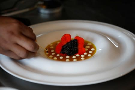 Chef Herilalaina Ravelomanana prepares a plate with Rova caviar at the Marais restaurant in Antananarivo