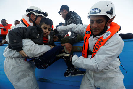 Rescuers of the Malta-based NGO Migrant Offshore Aid Station (MOAS) rescue a child migrant from a wooden boat in the central Mediterranean in international waters off the coast of Sabratha in Libya, April 15, 2017. REUTERS/Darrin Zammit Lupi