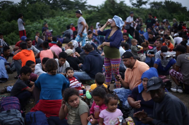 Migrants from Central America, part of a caravan travelling to the U.S., wait to cross into Mexico at the border between Guatemala and Mexico, in El Ceibo