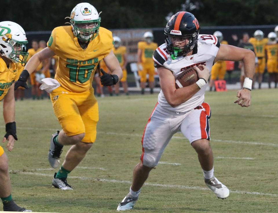 Spruce Creek High's Luke Smith #12 on a QB keeper as DeLand High's Kai Harkness #70 chases, Friday September 29, 2023 in Port Orange.